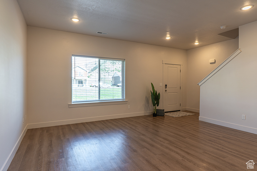 Unfurnished living room with recessed lighting, baseboards, visible vents, and wood finished floors