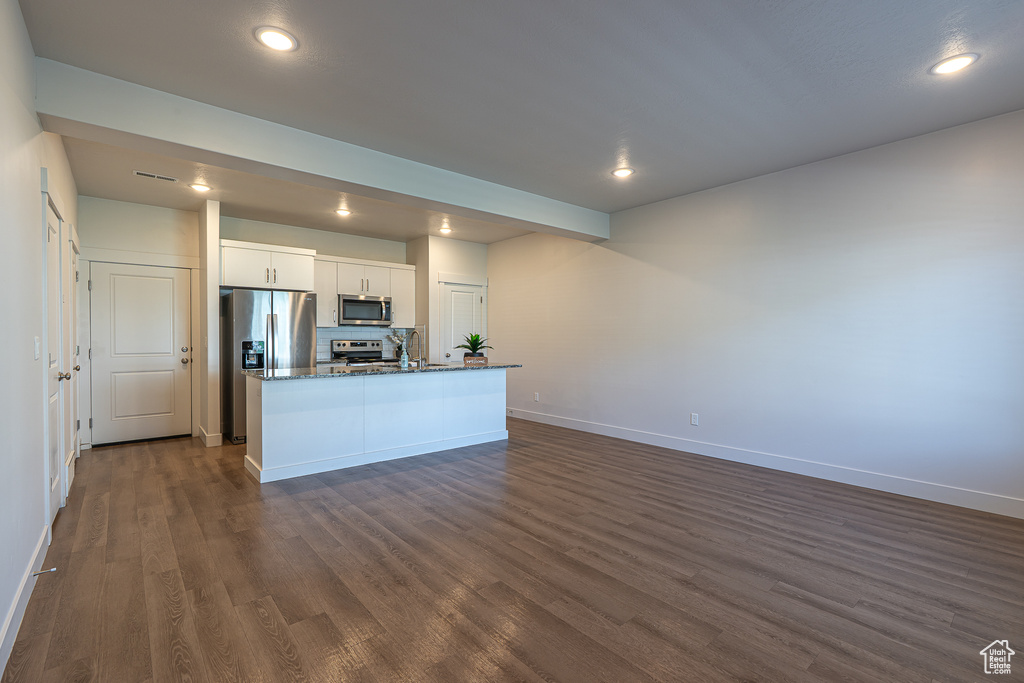Kitchen featuring baseboards, stainless steel appliances, recessed lighting, and dark wood-type flooring