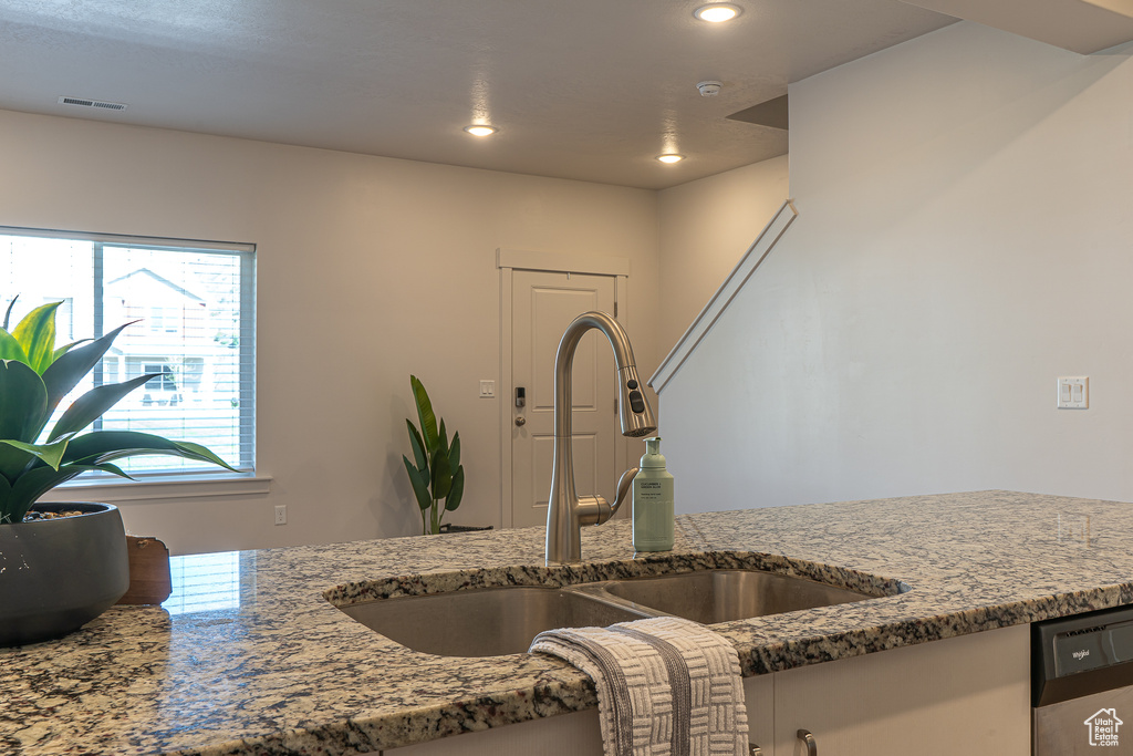 Interior details with a sink, stone countertops, recessed lighting, and visible vents