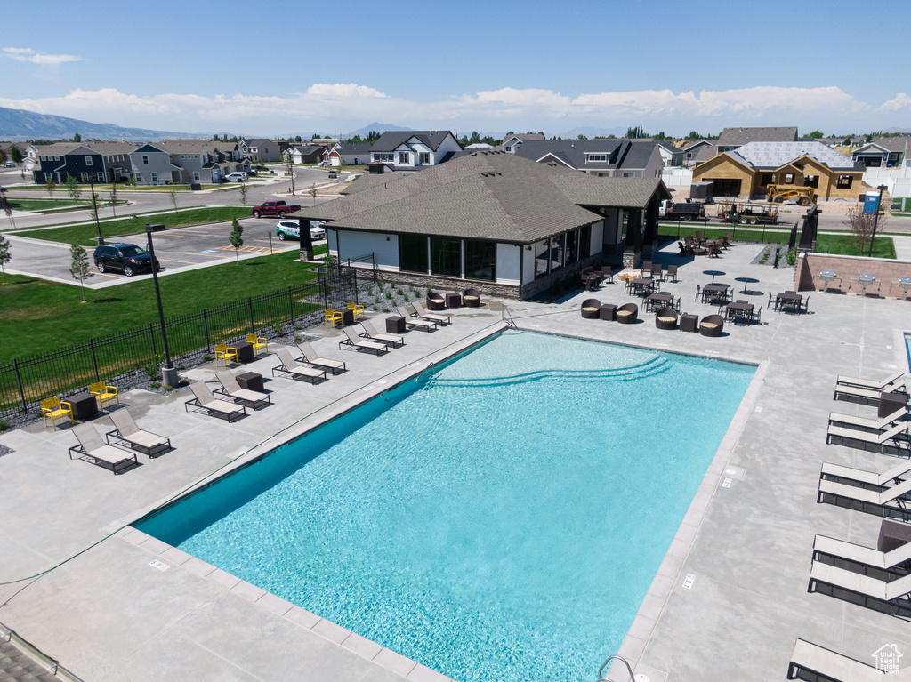 Community pool featuring a residential view, fence, and a patio area