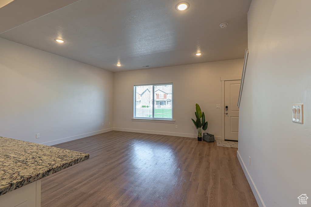 Unfurnished living room with baseboards, recessed lighting, and wood finished floors