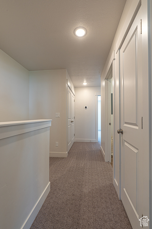 Hallway with carpet floors, baseboards, recessed lighting, and a textured ceiling