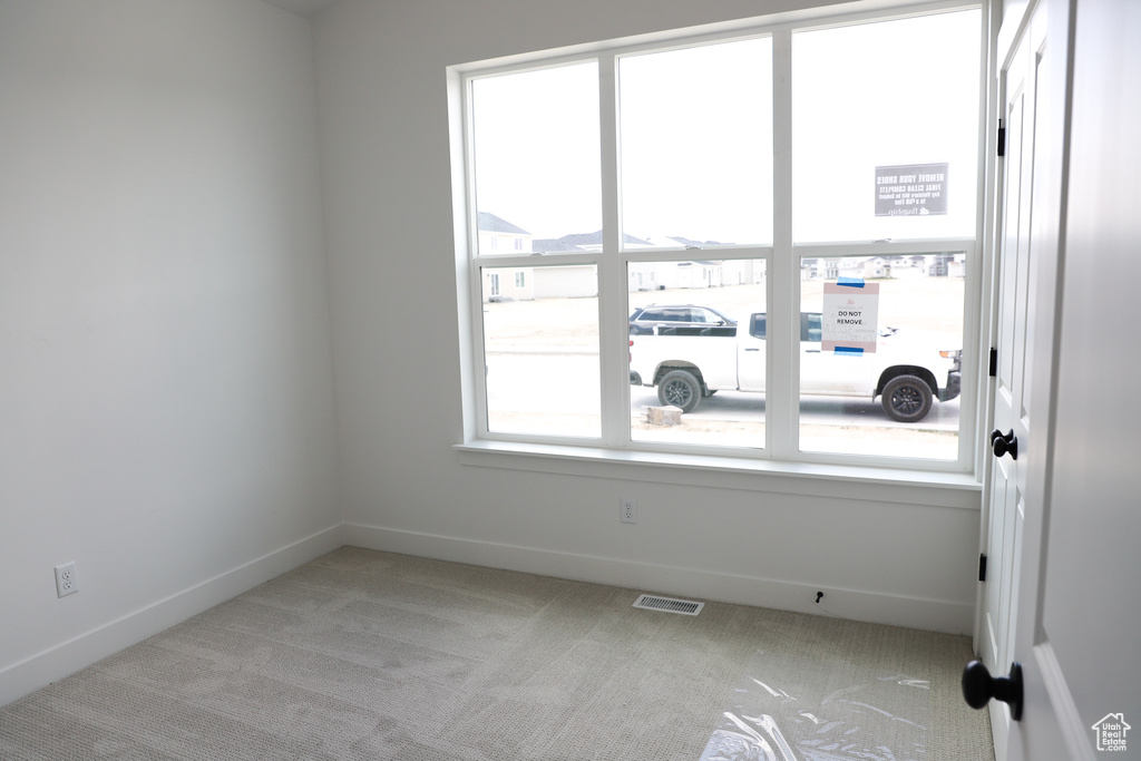 Unfurnished room featuring carpet floors, baseboards, and visible vents