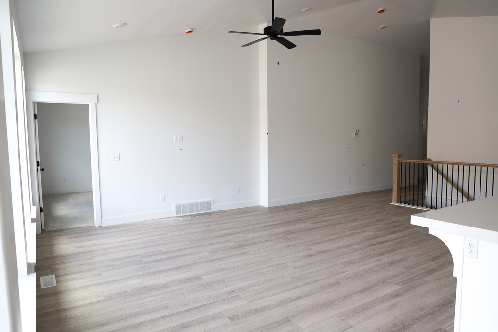 Unfurnished living room with baseboards, a ceiling fan, light wood-type flooring, and visible vents