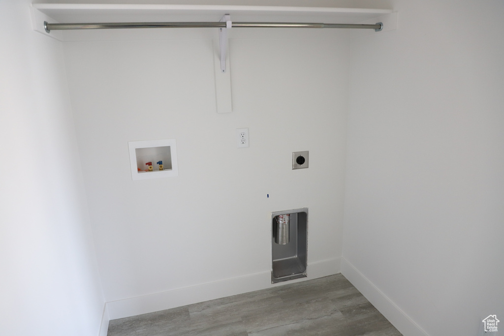 Washroom with hookup for an electric dryer, laundry area, wood finished floors, baseboards, and hookup for a washing machine