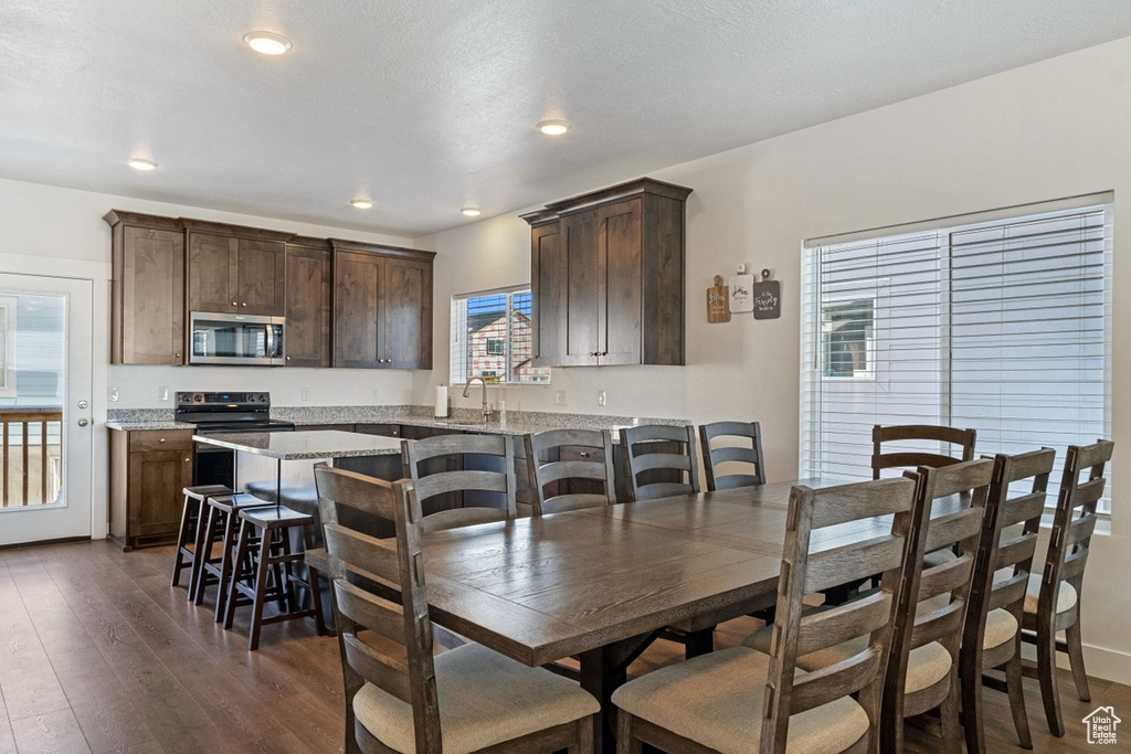 Dining area with recessed lighting and dark wood-style floors