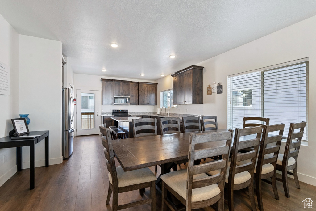 Dining room featuring dark wood-type flooring, recessed lighting, and baseboards