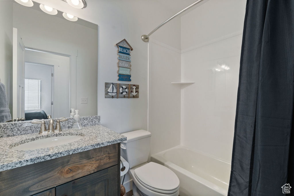Ensuite bathroom with connected bathroom, toilet, shower / bath combo, and vanity