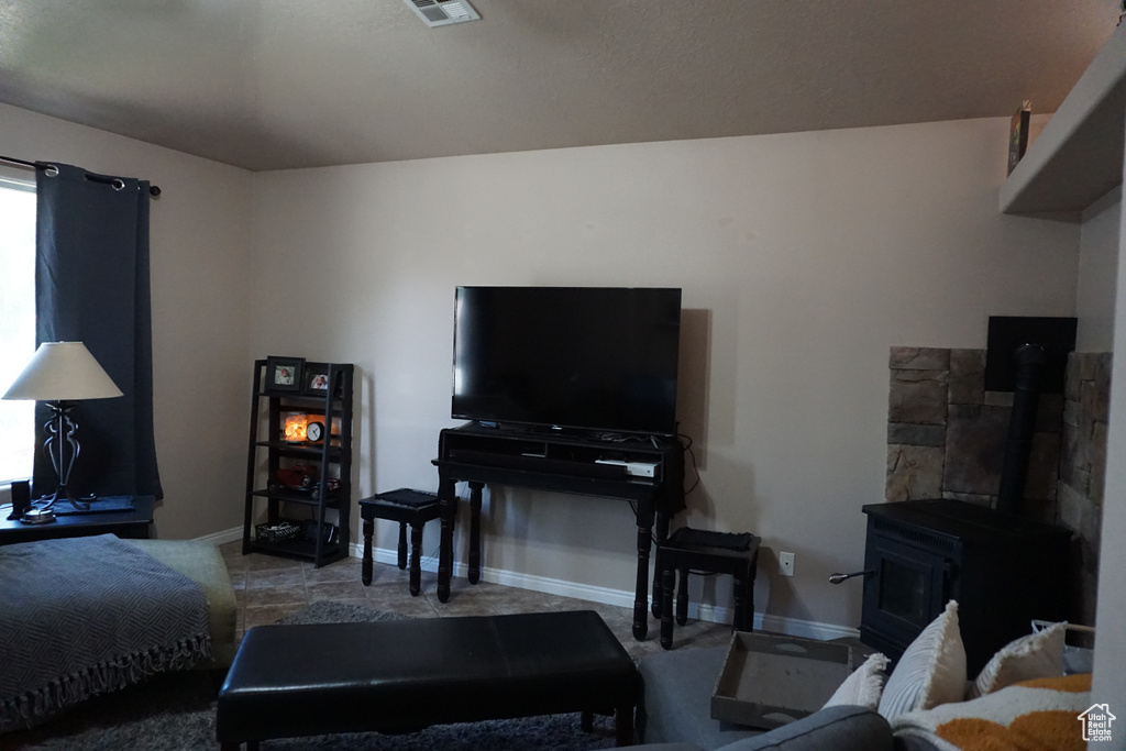 Living room featuring baseboards, a wood stove, and visible vents