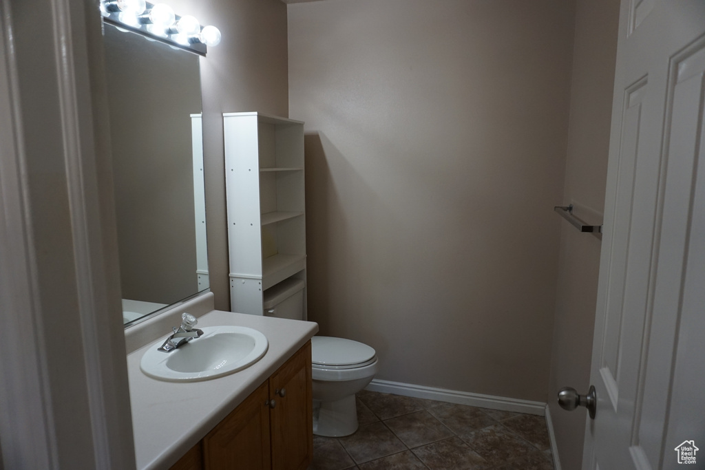 Bathroom featuring toilet, vanity, and baseboards