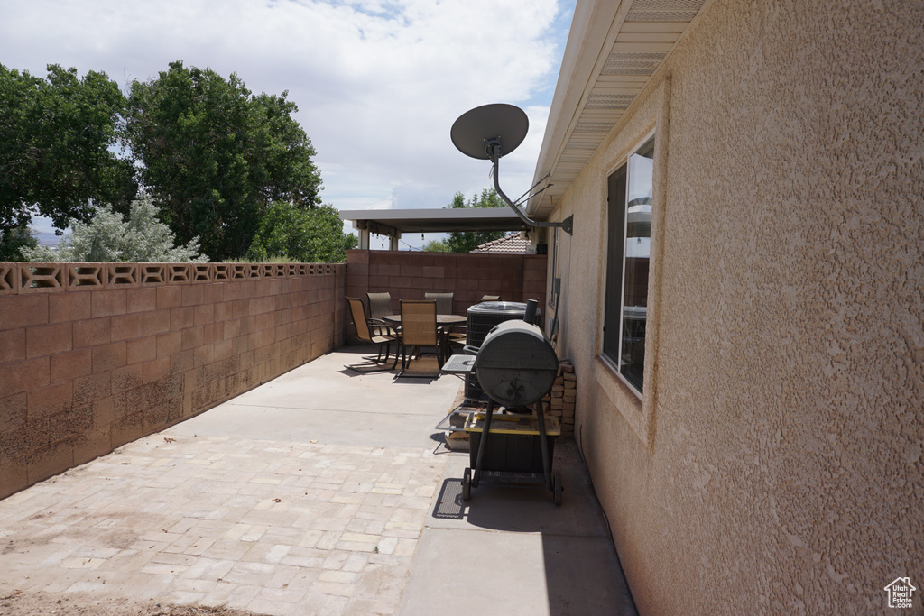 View of patio with central air condition unit, fence, and outdoor dining space