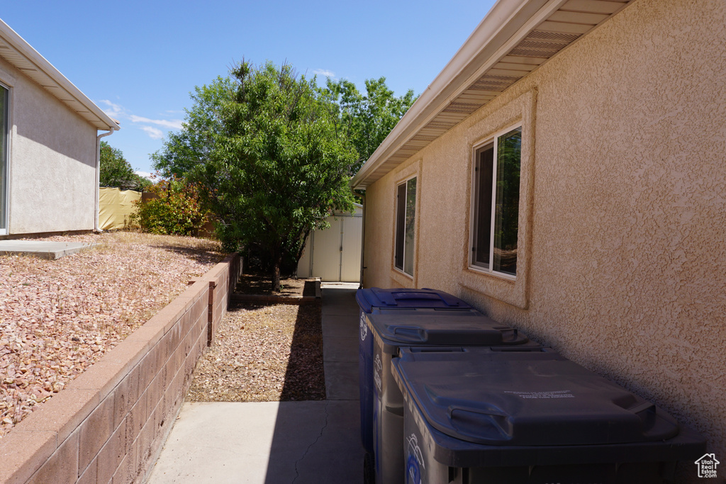 View of side of property with fence, a patio, and stucco siding