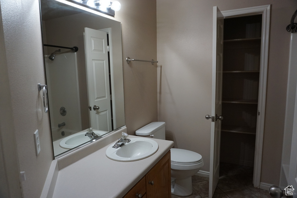Full bathroom featuring toilet, vanity, tile patterned flooring, and shower / washtub combination