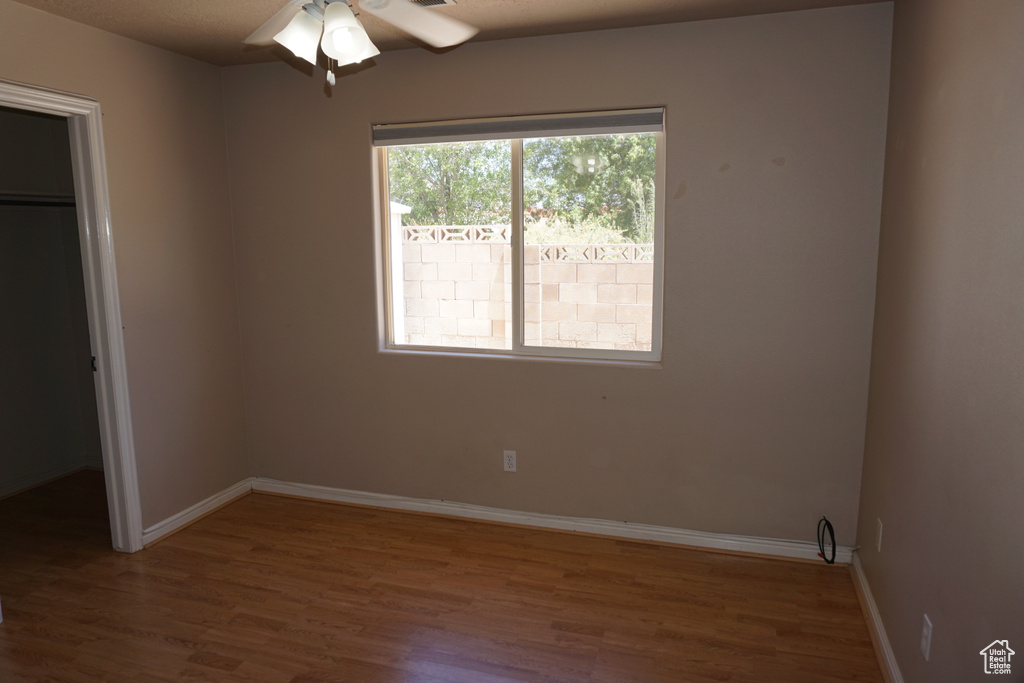 Unfurnished bedroom with wood finished floors, baseboards, and a closet