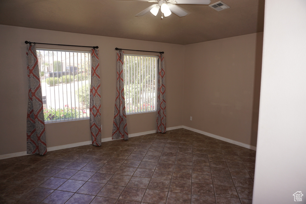Spare room with a ceiling fan and baseboards