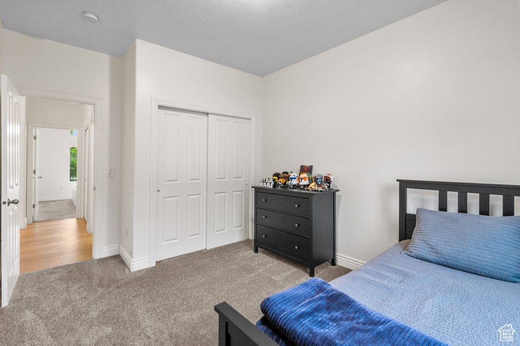 Carpeted bedroom with baseboards and a closet