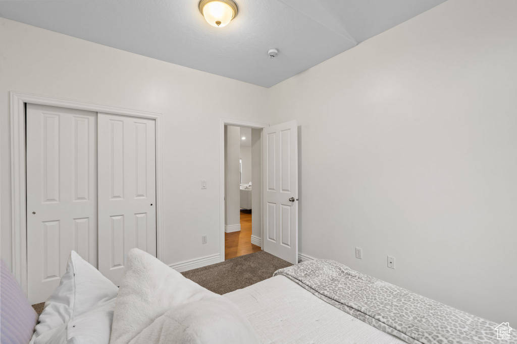 Carpeted bedroom featuring a closet and baseboards