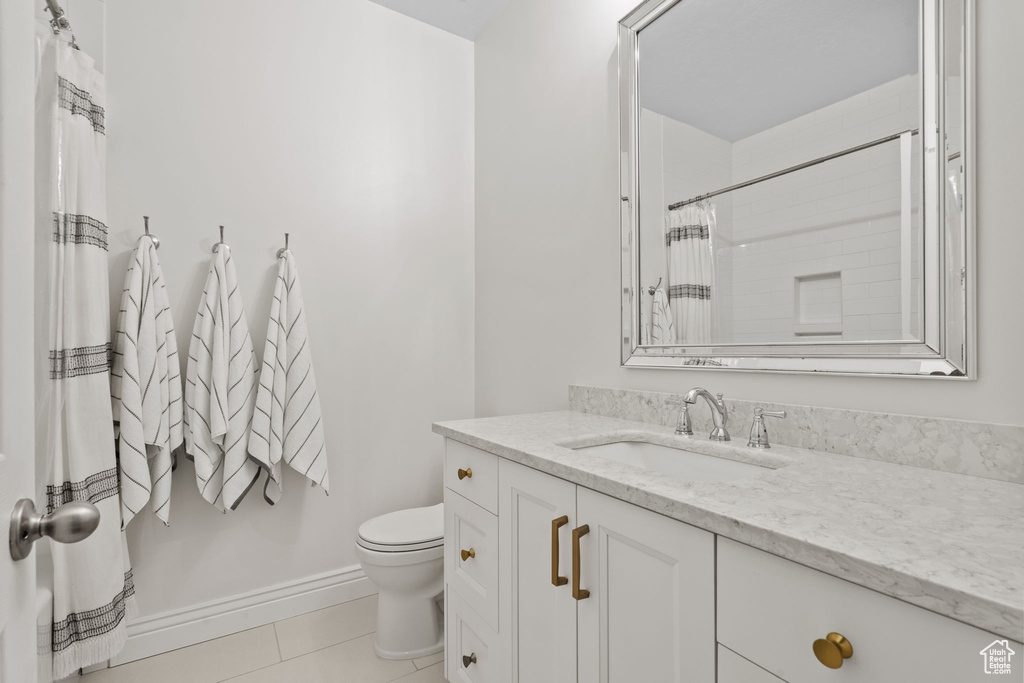 Full bathroom featuring toilet, tile patterned floors, a shower with shower curtain, and vanity