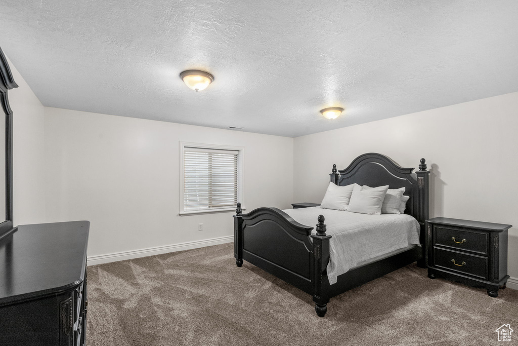 Carpeted bedroom with baseboards and a textured ceiling