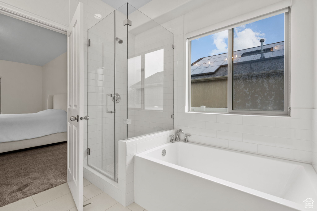 Full bath with tile patterned flooring, a stall shower, a bath, and connected bathroom