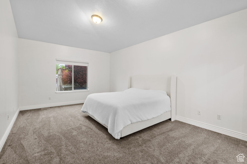 Bedroom featuring carpet floors and baseboards