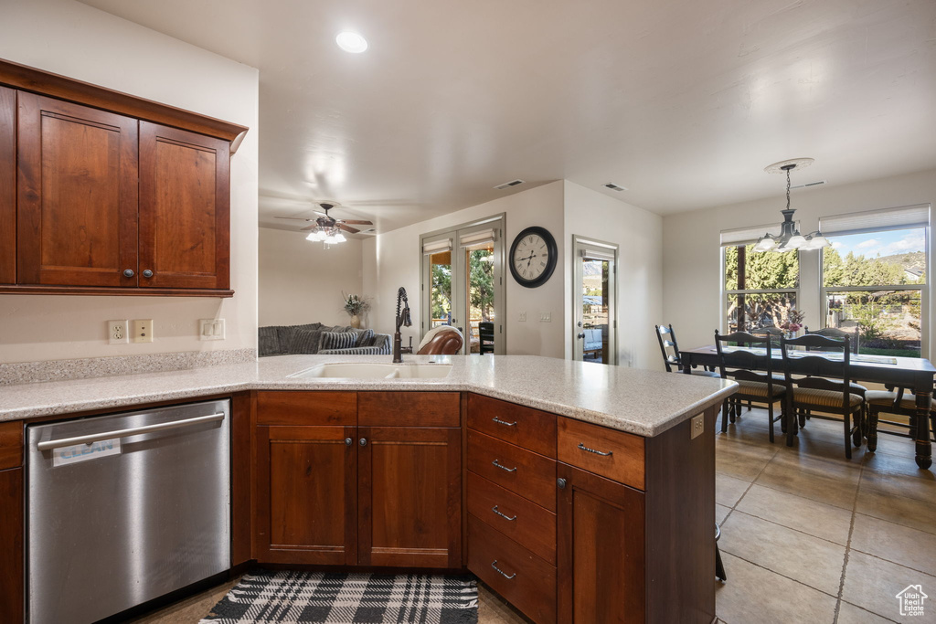 Kitchen with a sink, light countertops, stainless steel dishwasher, and a peninsula