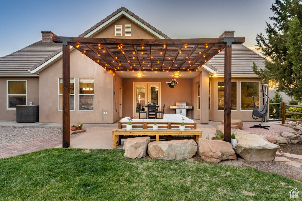 Rear view of house featuring a tiled roof, central air condition unit, a patio, a pergola, and stucco siding