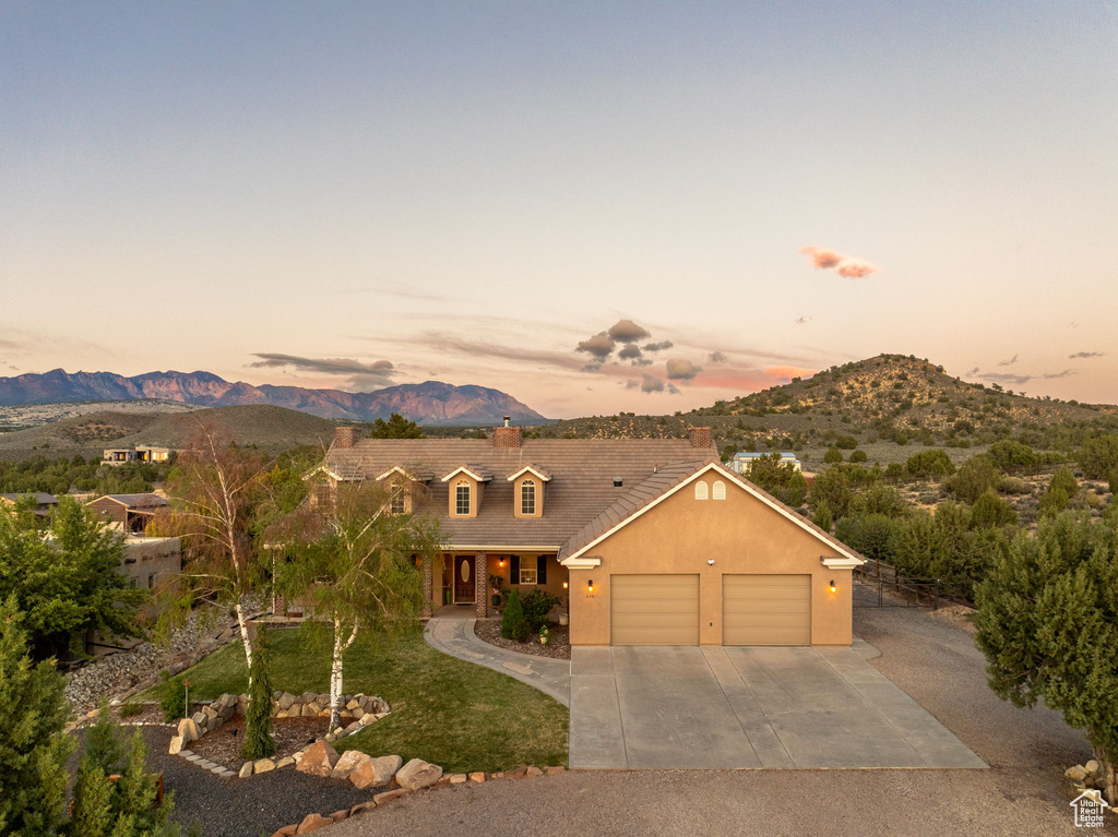 View of front of house with a garage, a mountain view, concrete driveway, and a porch