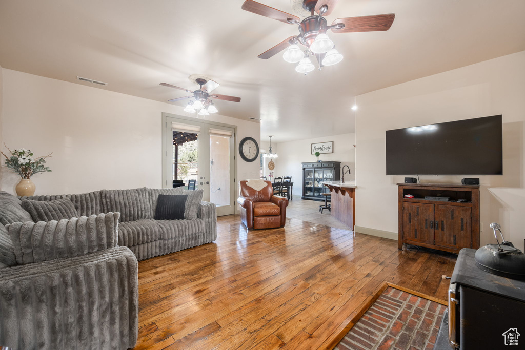Living room with ceiling fan, wood-type flooring, and visible vents