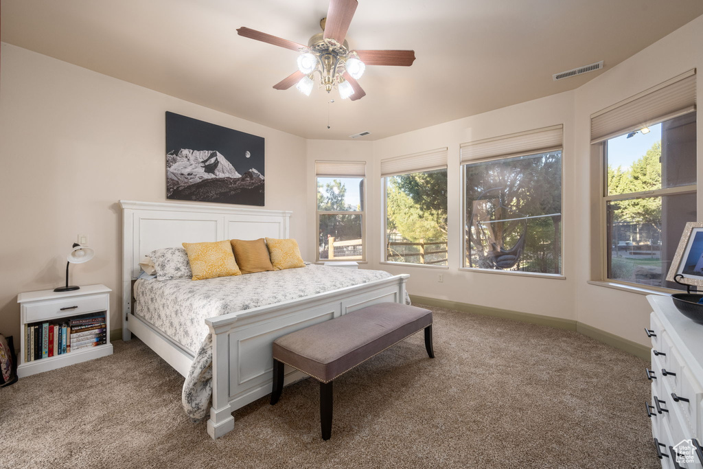 Bedroom with a ceiling fan, baseboards, visible vents, and carpet