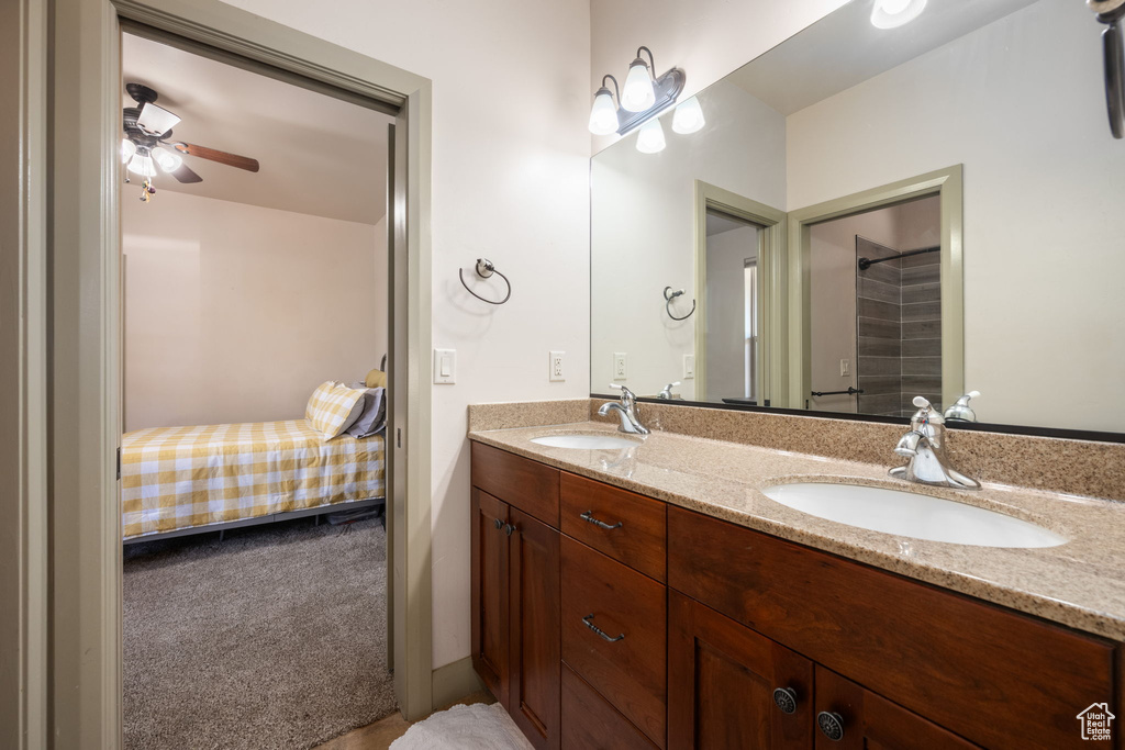 Bathroom with double vanity, a sink, ceiling fan, and ensuite bath