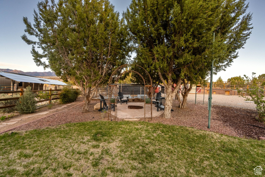 View of yard with fence and an outdoor fire pit