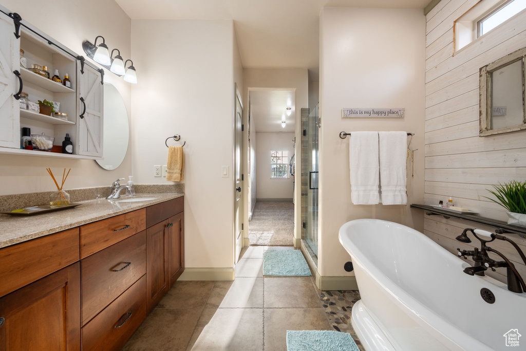 Bathroom featuring vanity, a freestanding bath, a wealth of natural light, and a shower stall