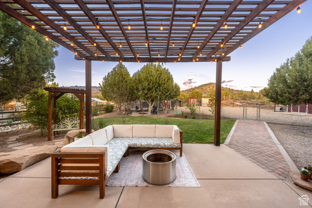 View of patio featuring an outdoor hangout area, fence, and a pergola