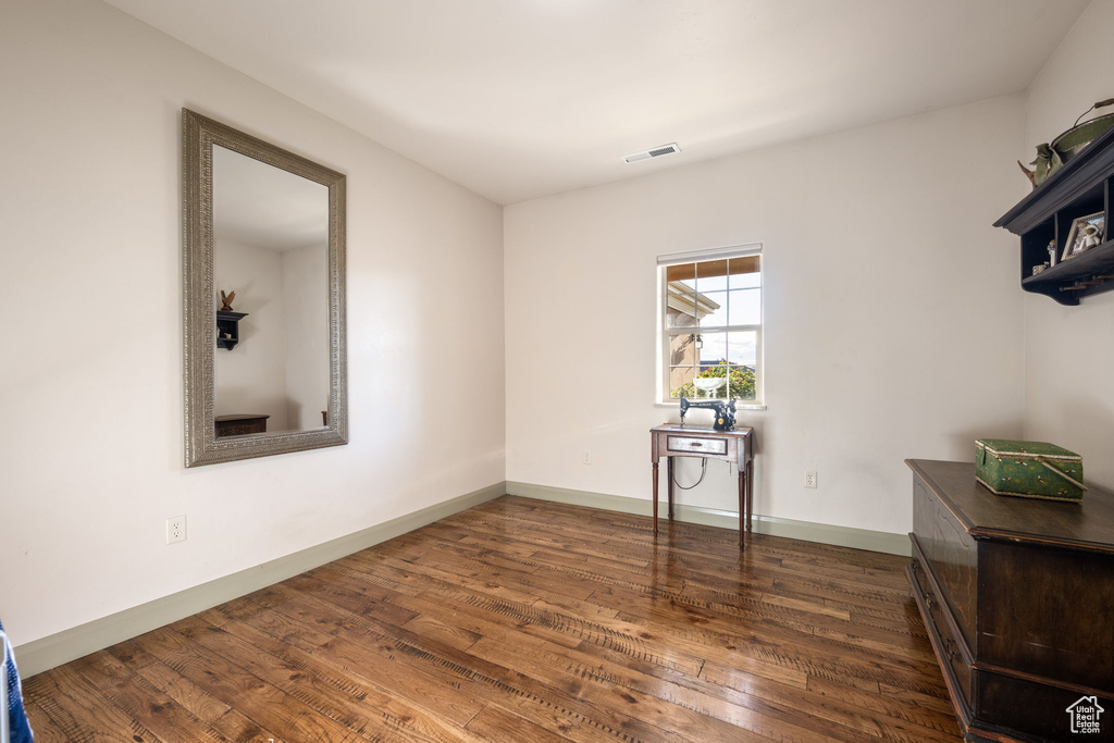 Unfurnished room with baseboards, wood finished floors, and visible vents