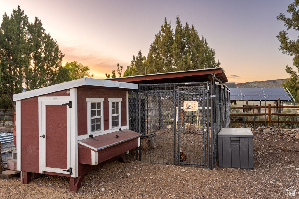 Outdoor structure at dusk with exterior structure, fence, and an outbuilding