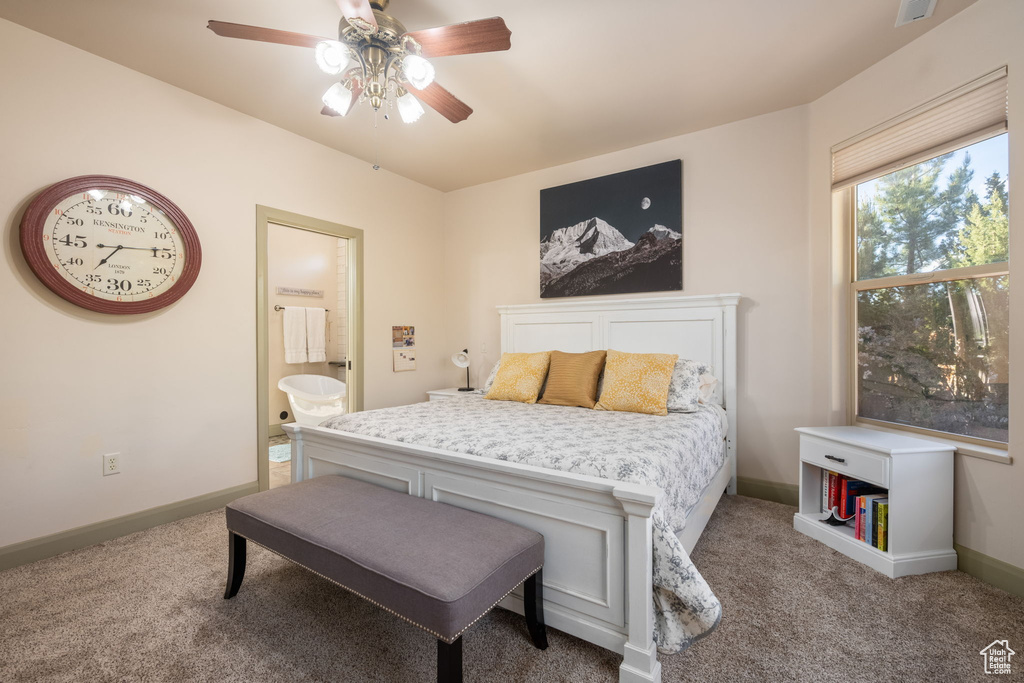 Bedroom with carpet floors, a ceiling fan, baseboards, and ensuite bathroom