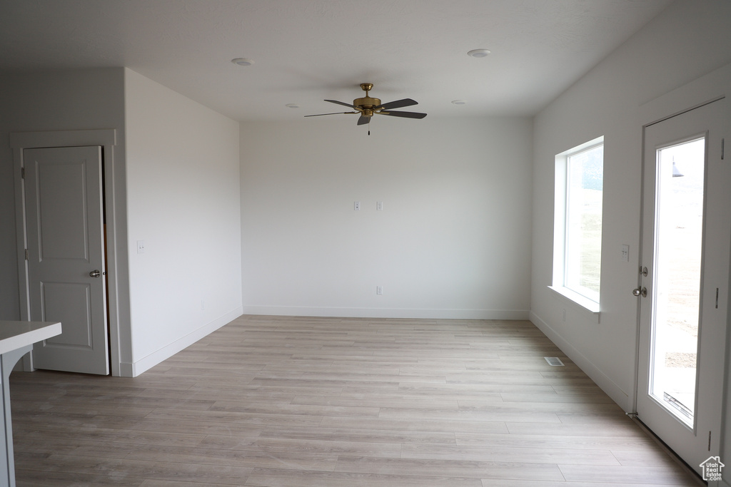 Unfurnished room with ceiling fan, baseboards, and light wood-style floors