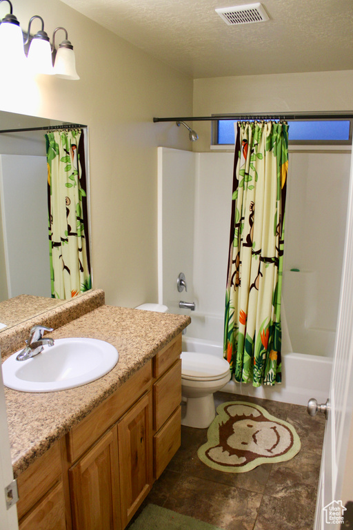 Full bathroom with visible vents, toilet, shower / tub combo, and vanity