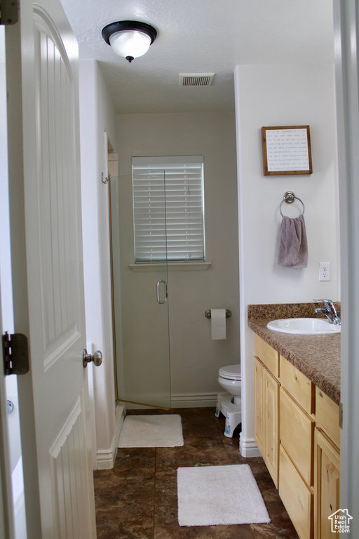 Full bathroom with baseboards, a stall shower, toilet, and visible vents