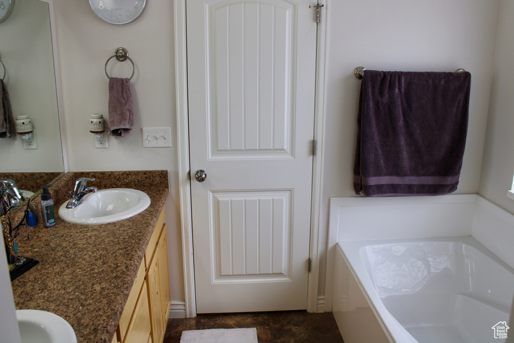 Full bathroom featuring a sink, a garden tub, and double vanity
