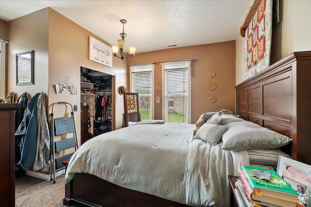 Bedroom featuring a chandelier, access to exterior, carpet, visible vents, and a closet