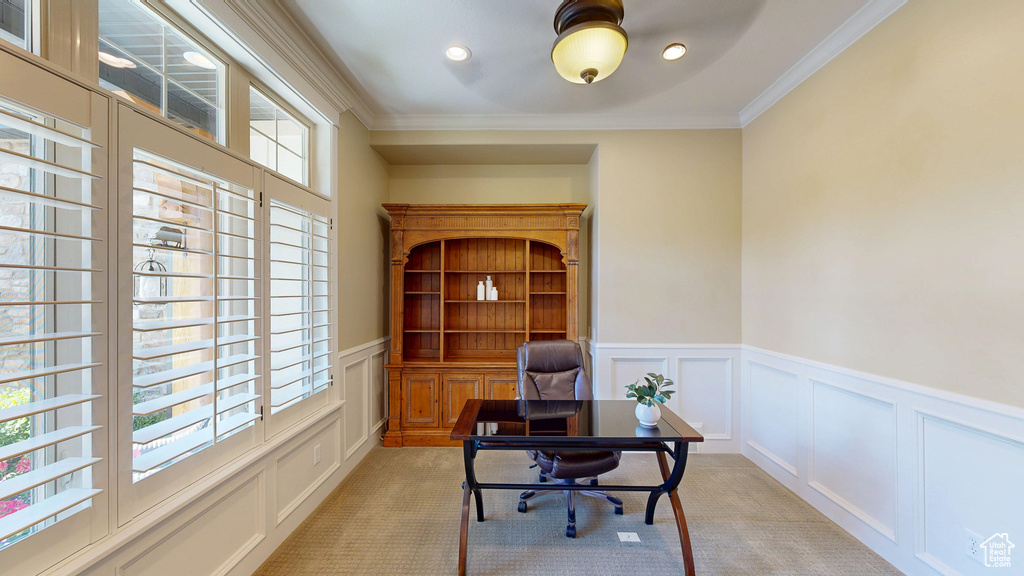 Home office featuring wainscoting, a decorative wall, and light carpet