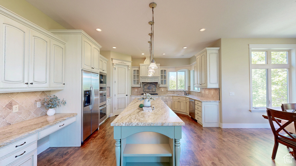 Kitchen with a kitchen island, appliances with stainless steel finishes, plenty of natural light, and a sink