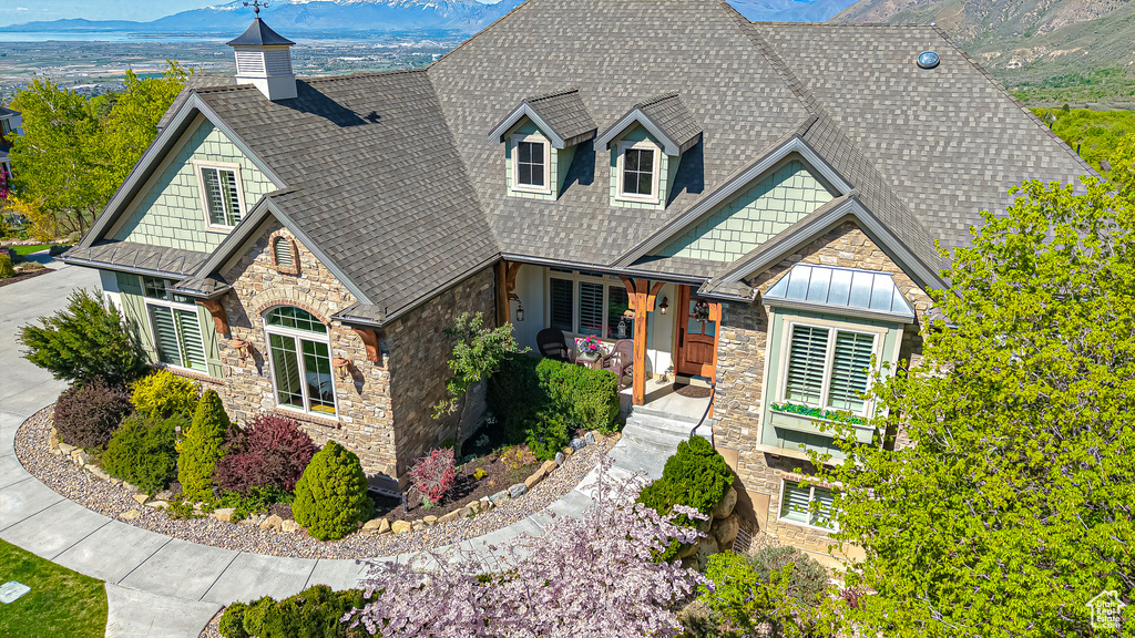 Craftsman-style house with roof with shingles, a mountain view, a standing seam roof, and stone siding