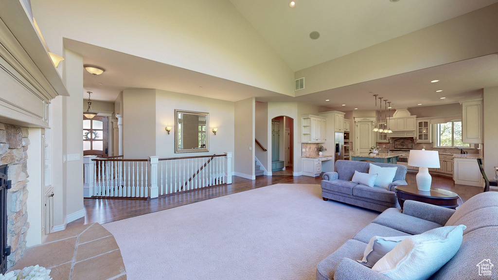 Living room featuring visible vents, a fireplace, baseboards, recessed lighting, and arched walkways