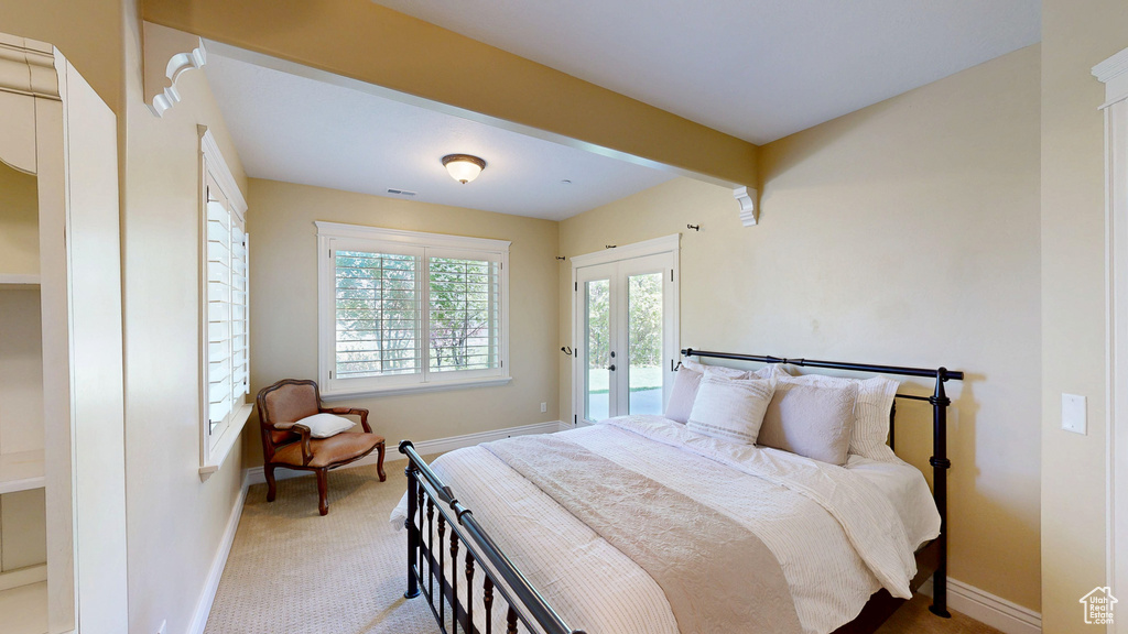 Carpeted bedroom featuring baseboards, visible vents, and access to exterior