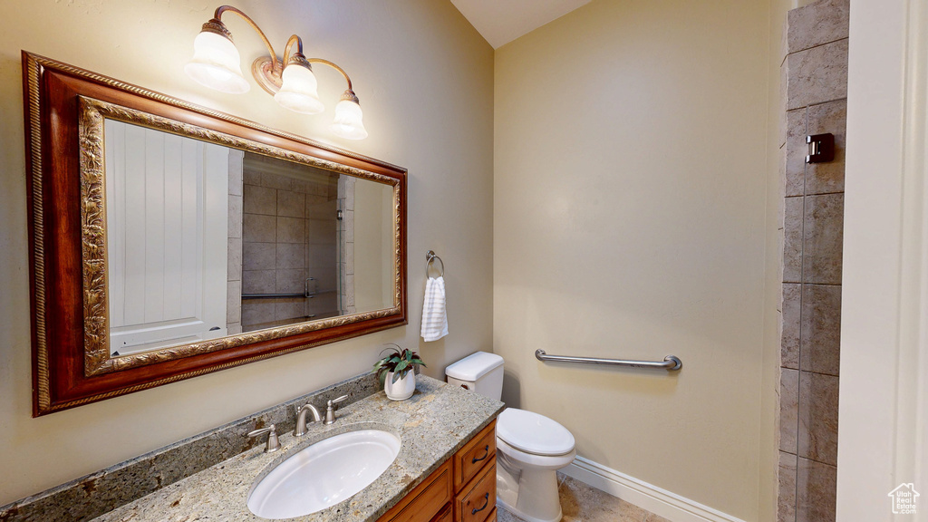 Bathroom with toilet, baseboards, and vanity