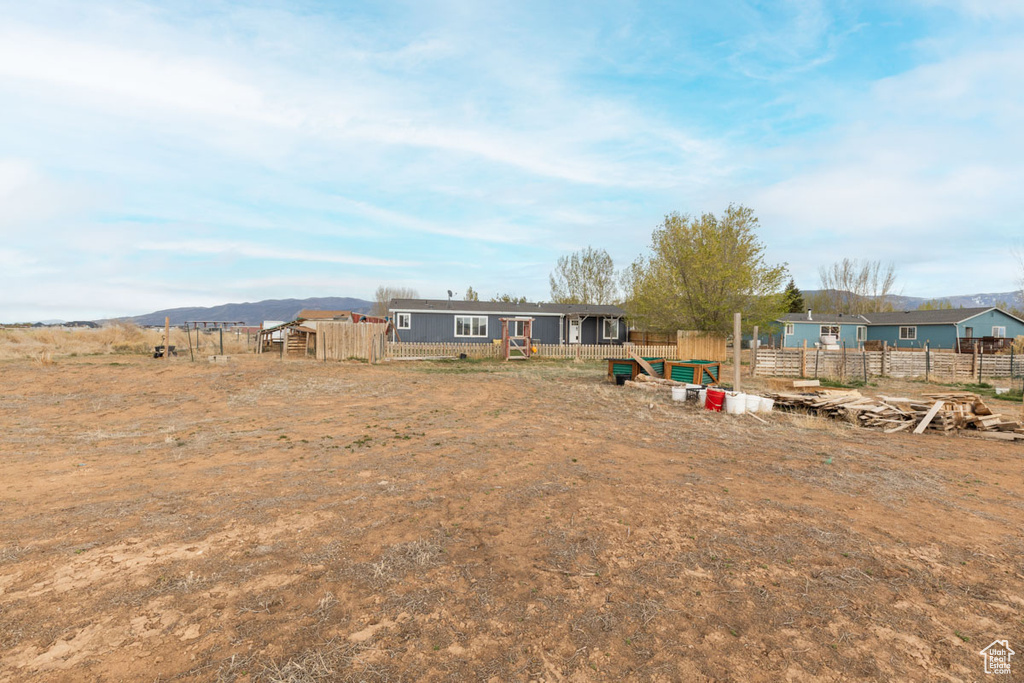 View of yard with a mountain view and fence