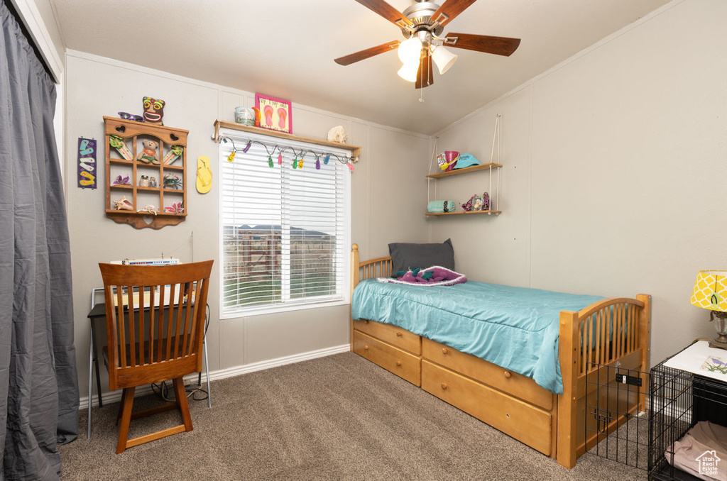 Carpeted bedroom featuring crown molding, baseboards, and ceiling fan